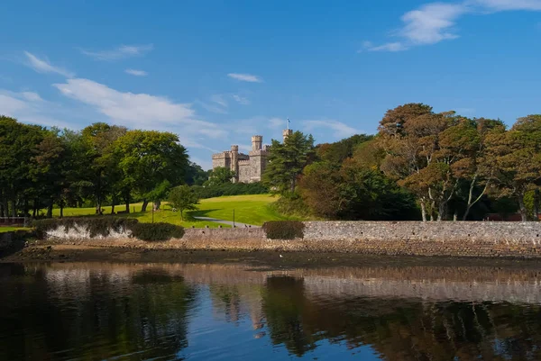 Marco e atração. Lews Castle em Stornoway, Reino Unido visto do porto marítimo. Castelo com terreno verde no céu azul. Arquitetura e design estilo vitoriano. Férias de verão e desejo de viajar — Fotografia de Stock