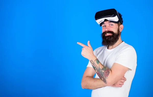 Hipster with long beard enjoying cyber space gaming, virtual reality concept. Cool man with trendy beard and confident look checking 3D video support. Bearded man with big smile wearing VR goggles