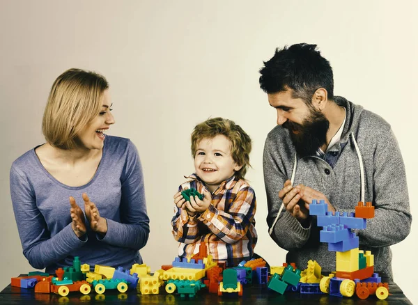 Koncepce mateřské školy a rodiny. Rodiče a dítě v herně. Rodina s rozzářenou tvář sestavení z barevné stavební bloky — Stock fotografie