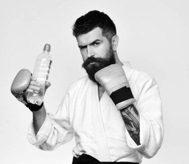 Savaş usta eğitimden sonra serinletici su içer. Sağlıklı yaşam ve spor kavram. Karate adam ciddi bir yüz ile