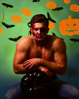 Canavar yüz ve göğüs üzerinde kan olan kabak üzerinde eğilir.