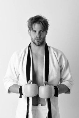Adam altın boks eldiven giymiş beyaz kimono teşkil etmektedir. Martial arts MMA savaşçı güçlü gövdeli uygulamaları.