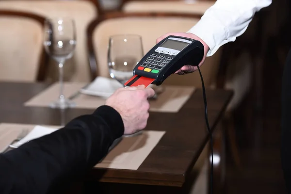 Man hand with credit card swipe through terminal for sale