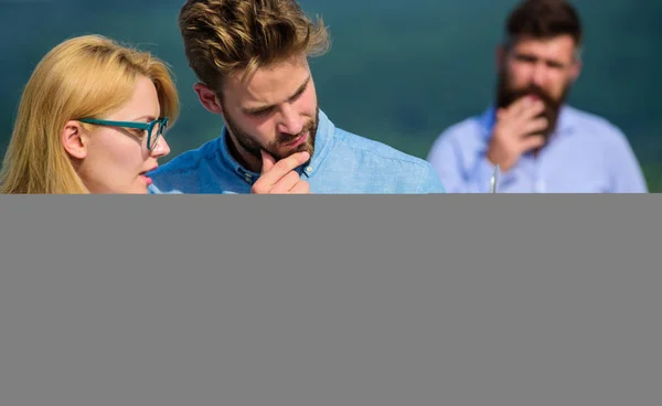 Couple works despite of coffee break. Workaholics concept. Colleagues working laptop, boss smoking while coffee break on background. Colleagues with laptop work outdoor sunny day, nature background