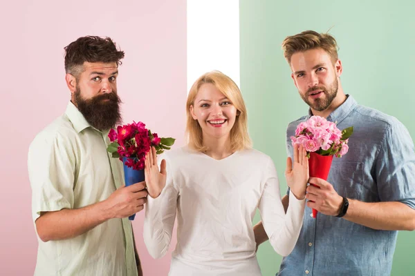 Los hombres competidores con ramos de flores tratar de conquistar chica. Chica sonriendo rechazar regalos. Fuera de relaciones. Concepto feminista. Mujer sonriente rechazar ambos compañeros masculinos. Chica popular recibir muchos hombres atención — Foto de Stock