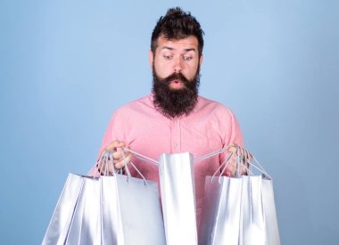 Satış ve indirim kavramı. Şok yüz bağımlısı alışveriş veya Alışverişkoliğin hippi. Satış sezon indirimlerle alışveriş adam. Sakal ve bıyık taşımak alışveriş torbaları, açık mavi renkli olan adam