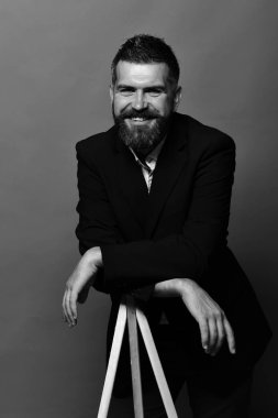 Fotoğraf ve meslek kavramı. Maço erkek fotoğraf makinesi tripod üzerinde kırmızı bir arka plan üzerinde eğilir