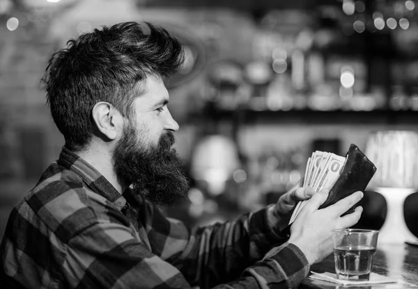 Wasting money on alcohol concept. Guy spend leisure in bar, defocused background.