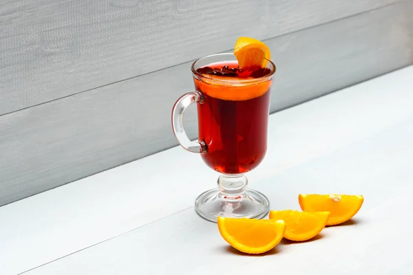 Bebida o bebida con naranja. Cóctel o bebida de vino caliente con jugo de naranja. Concepto de cóctel. Copa con vino caliente cerca de fruta naranja jugosa sobre fondo blanco, de cerca —  Fotos de Stock