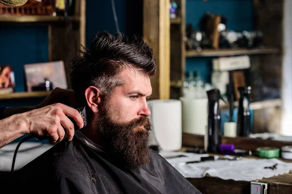 Berber makası ve tarak, elinde kapatın. Hippi saç modeli almak istemci sakallı. Berber kavramı. Kuaför saç kesme makinesi ile çalışır. Salonların sandalye, salon arka plan sakallı