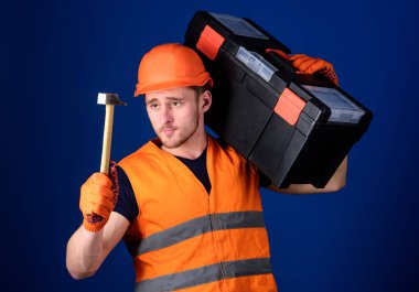 Kask, kask içinde adam araç kutusu taşır ve çekiç, mavi arka plan tutar. Tamirci kavramı. İşçi, repairer, tamirci, Oluşturucusu sakin yüz taşıyan araç omuz, onarım için hazır '