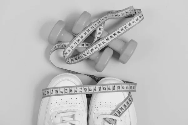 Sport shoes and equipment for healthy shape. Fitness and sportswear concept. Sneakers with measuring tape