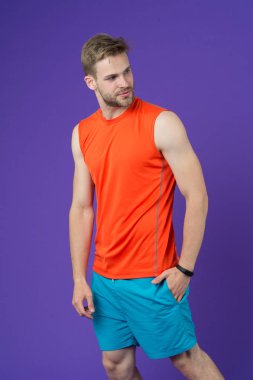 Menekşe arka plan üzerinde atlet. Spor giyim atletik bir adam. Sağlıklı yaşam için kişisel antrenör. Zinde ve kendinden emin. Spor moda eğitim ve egzersiz için. Fitness ve sağlıklı yaşam