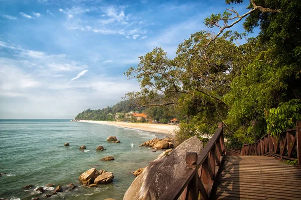 Adembenemende natuur van Kuantan. Beste badplaatsen Kuantan bekend om de ongerepte natuur. Kustlijn met tropic aard planten zand stranden. Bridge of houten pier in zee lagune met rotsen en golven — Stockfoto