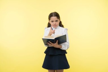 Daha iyi biliyorsun. Ev ödevi ile yapılan çocuk okul üniforma akıllı çocuk. Kız sevimli ciddi yüz sarı arka plan. Çocuk kız okul tek tip kıyafet kitap ve kalem tutar. Onay bilgi kavramı.