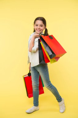 Benim stilini değiştirin. Çocuk şirin fashionista alışveriş. Alışveriş merkezinde alışveriş mutlu bir çocuk. Çocuk kız yüzü gülen taşıyan grup mutlu sarı arka plan paketler. Kız Alışverişkoliğin alışveriş satın giyim seviyor