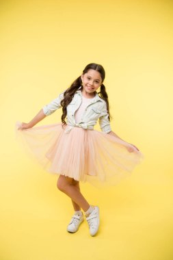 Little girl smile on yellow background. Happy child with stylish hairdo. Fashion model agency for kids. I like this skirt. Fits perfectly. Designer atelier school for future tailor. Adorable look clipart