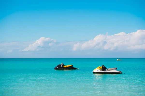 Extreme entertainment. Pair water scooter in turquoise ocean lagoon wait for extreme riding. Ocean beach st.johns resort equipped with modern water scooters for clients pleasure and fun. Water riding — Stock Photo, Image