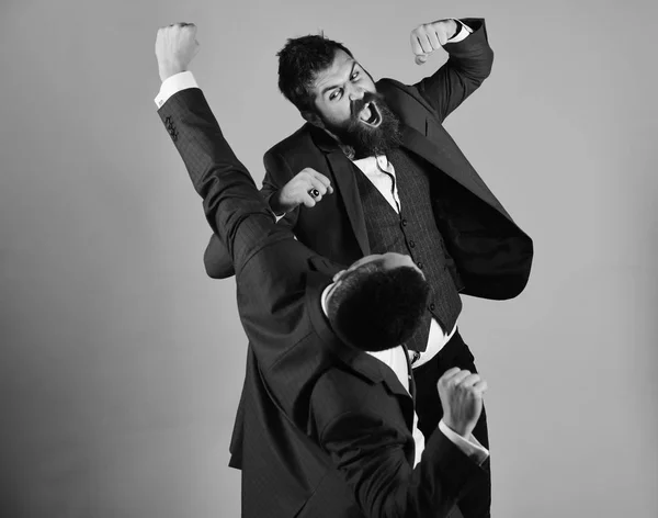 Podnikatel s rozzuřenou tvář zasáhne a údery soupeře. Muži s vousy bojovat na červeném pozadí. — Stock fotografie