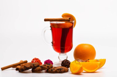 Kokteyl bar kavramı ve. Cam mulled şarap veya portakal dilimleri ve çerezleri beyaz arka plan üzerinde yakın sıcak elma şarabı ile. Portakal dilim yakınındaki mulled şarap. İçki ya da portakal ve tarçın ile içecek