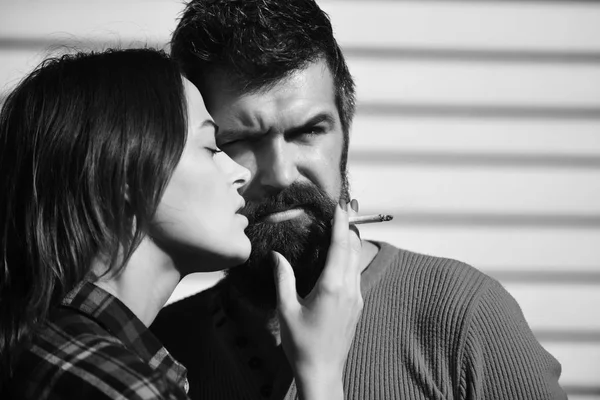 Tabagismo e conceito de relacionamento de hábito. Homem e mulher com rostos sérios em fundo listrado branco — Fotografia de Stock