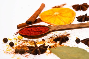 Baharat seti hazırlamak için mulled şarap ya da sıcak içecek, yakın çekim. Sıcak içecekler baharat seti. Baharat Seti kavramı. Kaşık ile baharat, kurutulmuş portakal, tarçın, kakule ve beyaz zemin üzerine Hindistan cevizi