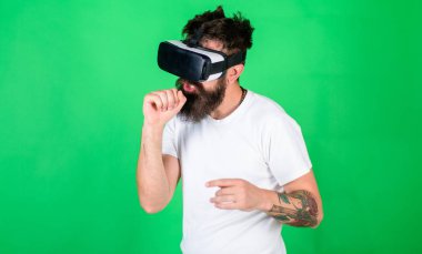 Vr gözlük, yeşil arka planda sakallı adam. Hayali mikrofonla şarkı Vr gözlüklü adam. Hipster meşgul yüzündeki eğlence ya da eğitim için modern teknolojiler kullanın. VR müzisyen kavramı.