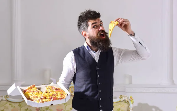Sakal ve bıyık teslim tutar kutusu lezzetli taze sıcak pizza ile olan adam. Pizza teslim kavramı. Dilim pizza yeme, beyaz arka plan, maço klasik giysiler aç neşeli yüzünde ısırıkları. — Stok fotoğraf