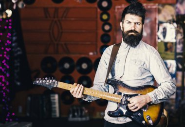 Yetenekli müzisyen, solist, şarkıcı oyun gitar müzik kulübü arka plan üzerinde. Sakallı müzisyen elektro gitar çalmak. Rock müzik konsepti. Adam kesin yüz oyun gitar, şarkı şarkı, müzik çalma