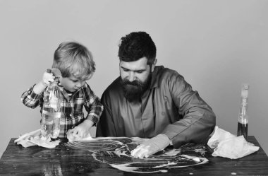 Temizlik sünger ile birlikte baba ile oğlu. Babalık kavramı. Adam pembe bir arka plan üzerinde şirin çocuk ile.