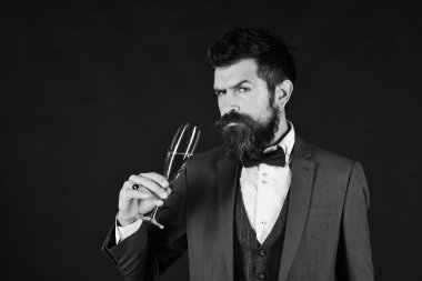 Resepsiyon kavramı. Sakallı adam şampanya kahverengi zemin üzerinde tutar. Zor yüz ve köpüklü içecek ile iş adamı. Maço