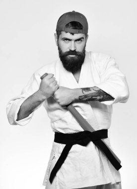 Beyzbol oyuncusu ciddi bir yüz ile yeşil beysbol sopası siyah kuşak arkasına koyar. Master savaşmaya hazır hale getirilir. Dövüş sanatları kavramı.