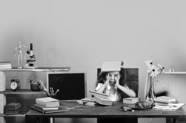 Sarı duvar arka plan üzerinde çocuk ve okul malzemeleri. Ev ödevi ve çalışma zaman kavramı. Danışma kitaplar ile kız