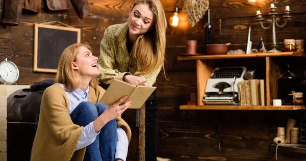 Ragazze che leggono insieme, attività ricreative in famiglia. Teenager studiare letteratura con sua madre, concetto di educazione a casa. Madre e figlia che si guardano e ridono di una scena divertente nel libro — Foto Stock