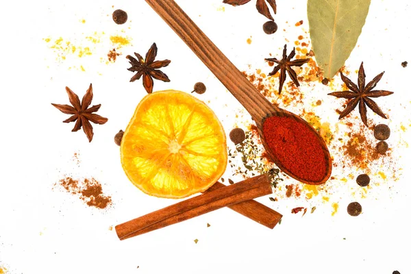 Baharat Seti pişirme veya sıcak içecekler, hazırlama kapatın. Baharat mutfak otlar ve kuru malzemelerle karıştırın. Baharat Seti kavramı. Kaşık, kurutulmuş portakal ve tarçın beyaz arka plan üzerinde sopa