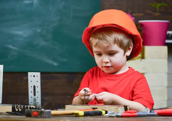 Çocukluk kavramı. Çocuk Oluşturucusu'nu veya repairer oynamak, aletlerle çalışırız. Gelecekteki kariyer mimarisi veya bina hakkında rüya çocuk. Turuncu baret veya kask, çalışma odası arka plan çocuk evlat