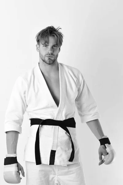 Estilo de vida saludable y concepto de boxeo. Guy posa en kimono blanco usando guantes de boxeo dorados —  Fotos de Stock