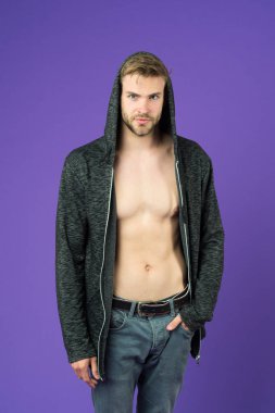 Çıplak gövde kapüşonlu adam. Gri kot kırpılmış şık sakallı hippi. Mükemmel kas vücut adamla. Seksi yakışıklı modeli üzerinde mor arka plan izole. Sokak tarzı gençlik moda