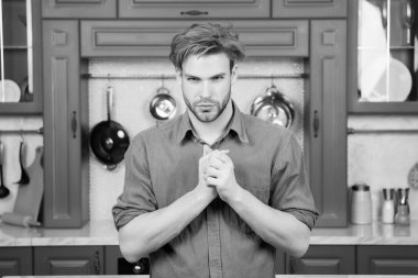 Maço ile ciddi bir yüz, sarı saçlı mavi gömlekli hazır mutfak katlanmış parmak ile. Yiyecek hazırlama, kavram yemek mutfağı.