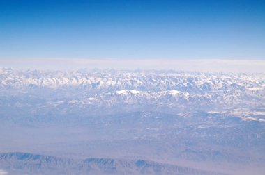Dünya ve mavi gökyüzü, havadan görünümü. Dağ manzarası. Çevre koruma ve ekoloji. Yolculuk tutkusu ve seyahat. Dünya büyük bir ev sahibi olduğunu