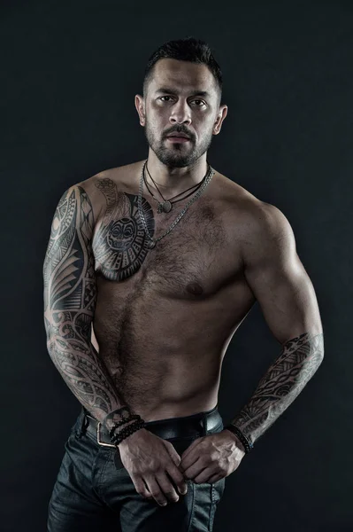 Uomo barbuto con corpo tatuato. Uomo con torso nudo sexy in jeans. Modello tatuaggio con sei pack e ab. Atleta o sportivo con petto e pancia muscolosi. Sport o fitness e cura del corpo, filtro vintage — Foto Stock