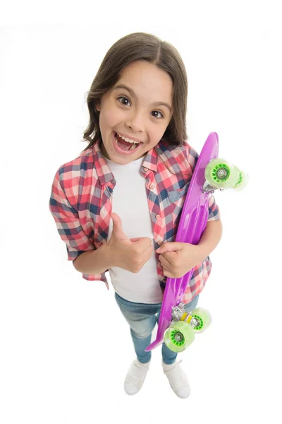 Boa escolha. Miúda feliz tem penny board. Criança gosta de skate de plástico mostra polegar para cima. hobby adolescente moderno. Menina cara feliz carrega penny board fundo branco. Aprender a montar penny board — Fotografia de Stock