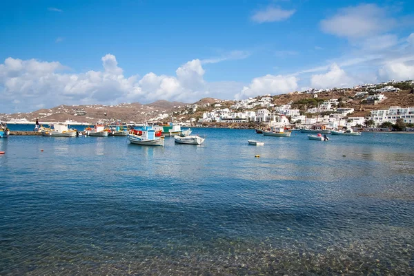 Barcos na água do mar em Mykonos, Grécia. Aldeia marítima no céu azul nublado. Casas brancas na paisagem da montanha com arquitetura agradável. Férias de verão na ilha mediterrânea. Wanderlust e viajar — Fotografia de Stock