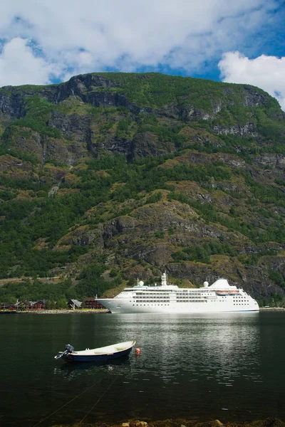 Boot und Kreuzfahrtschiff im Meer auf Berglandschaft in Flam, Norwegen. Seeschiffe im Hafen mit grünen Bergen. Reisen auf dem Wasser. Sommerurlaub und Urlaub. Fernweh und Entdeckung — Stockfoto