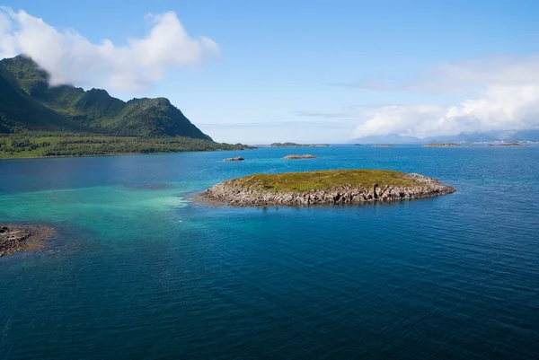 Descubre el mundo. Crucero por el mundo. Isla pedregosa rodeada de idílica agua de mar en Noruega. Paisaje marino con isla en día soleado. Isla de acantilados pedregosos costa. Los mejores lugares para visitar en Noruega — Foto de Stock