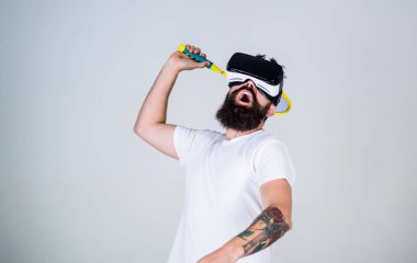 Vr bardaklarda sakallı adam play tenis, gri arka plan. Vr gözlüklü play tenis raket ve top ile. Hipster meşgul yüzündeki spor oyunları için modern teknolojisini kullanıyor. Sanal spor kavramı