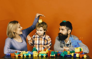 Anne ve çocuk oyun odası. Anaokulu ve Aile kavramı. Sakal, kadın ve çocuk oyun kırmızı zemin üzerine olan adam. Meraklı yüzü olan aile kurmak dışarı renkli İnşaat blokları.