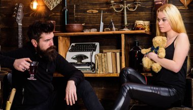 Çift gamekeepers evde, ahşap iç arka plan romantik akşamın. İki aşık oyuncak ayı ve mulled şarap. Kız ve erkek rahat yüzleri sıcak atmosferinin keyfini çıkarın. Rahatlatıcı kavramı