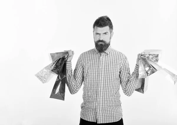 Conceito de compras e venda. Homem com barba e rosto sério isolado sobre fundo branco. Macho com pacotes brilhantes coloridos. Cara de camisa xadrez detém sacos de compras — Fotografia de Stock