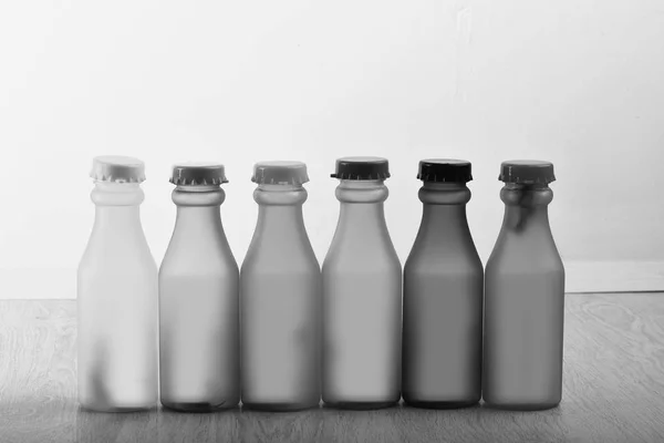 Conjunto de garrafas em cores diferentes. Fila de refrigerantes coloridos em fundo cinza — Fotografia de Stock